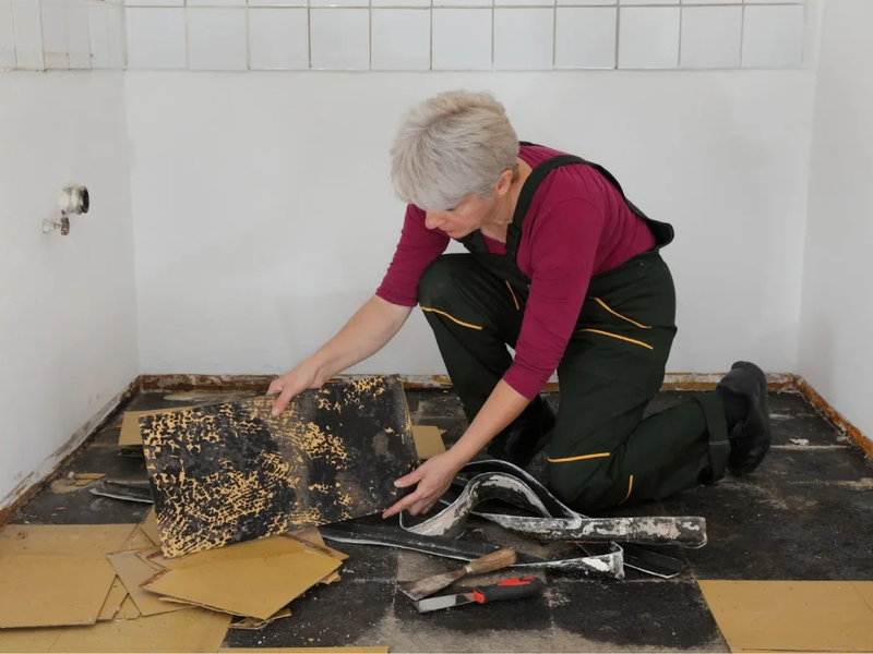 Woman removing vinyl flooring